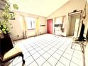 Spacious living room with tile floors, large windows, and a red front door at 3620 Park Oliver Dr, Las Vegas, NV 89110