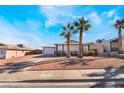 Single story home with landscaped yard, driveway, and palm trees at 421 Box Elder Way, Henderson, NV 89015