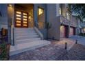 Inviting entryway featuring a modern glass front door, stone accents, and well-maintained landscaping at 6276 Olde Lockford Ct, Las Vegas, NV 89139