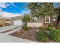 Inviting single-story home with well-manicured landscaping, a two-car garage, and a cozy front entrance at 6886 Barred Dove Ln, North Las Vegas, NV 89084