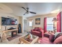 Living room with fireplace, red sofa and large TV at 9224 Nerone Ave, Las Vegas, NV 89148