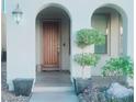 Home features arched entryway, wood door, and potted plants at 927 Via Canale Dr, Henderson, NV 89011