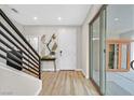 Light and bright entryway with wood-look floors, modern staircase, and access to a private sauna at 10273 Sierra Skye Ave, Las Vegas, NV 89166