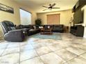 Comfortable living room features a large sectional couch, ceiling fan, and bright windows at 1136 Buckhorn Cove St, Henderson, NV 89011