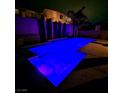 Outdoor swimming pool illuminated with blue lighting, creating a serene ambiance at night at 1136 Buckhorn Cove St, Henderson, NV 89011