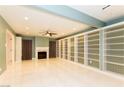 Spacious living room featuring custom built-in shelving, fireplace, tile flooring, and ceiling fan at 1403 5Th Pl, Las Vegas, NV 89104