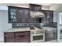 Gourmet kitchen featuring dark wood cabinets, stainless steel appliances, and granite countertops at 2540 Youngdale Dr, Las Vegas, NV 89134