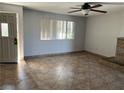 Neutral living room with tile flooring, ceiling fan, brick fireplace, and natural light from the window at 2679 Jacyra Ave, Las Vegas, NV 89121