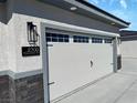 A close up of the three car garage showcasing the address and exterior lighting at 2700 W Carnation Way, Pahrump, NV 89048