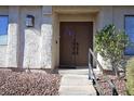 Close up of the double front doors showing stone walkway, metal handrail, and charming wreath at 3126 Asoleado Cir, Las Vegas, NV 89121