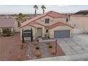 Aerial view of a charming home with a tile roof, desert landscaping, and a two-car garage at 319 Horse Pointe Ave, North Las Vegas, NV 89084