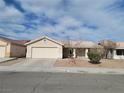 Single-story house with a garage and landscaped yard at 320 Mindoro Ave, North Las Vegas, NV 89031