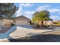 Inviting single-level home featuring a wide driveway and a desert-landscaped front yard with a palm tree at 551 Morning Mauve Ave, Las Vegas, NV 89183