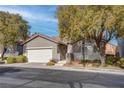 Single-story home with attached garage and front landscaping at 5600 Nimes Ave, Las Vegas, NV 89141