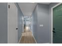 Light gray hallway with wood-look floors and doors to rooms at 59 N Christy Ln, Las Vegas, NV 89110