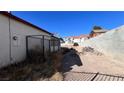 Backyard with chain link fence, satellite dish, and a dirt area at 6166 Evensail Dr, Las Vegas, NV 89156