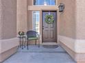 Inviting entryway with wreath, chair, and side table at 8501 Vivid Violet Ave, Las Vegas, NV 89143