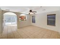 Bright living room featuring tile floors, two windows, and open access to the kitchen at 8889 W Torino Ave, Las Vegas, NV 89148