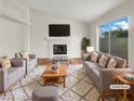 Virtually staged living room with fireplace and large windows at 9570 Lavarun Ct, Las Vegas, NV 89123