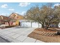 Two-story home featuring a concrete driveway and an attached two-car garage at 9916 Sierra Canyon Way, Las Vegas, NV 89147