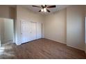 Bright bedroom with wood flooring, double closet, ceiling fan, and ample natural light at 8682 Waterford Bend St, Las Vegas, NV 89123