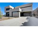 Modern home exterior with a sleek design, large driveway, and minimalist landscaping at 1469 Dragon Stone Pl, Henderson, NV 89012