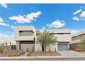 Modern home with attached two-car garage and desert landscaping at 21 Canyon Bay Dr, Henderson, NV 89011