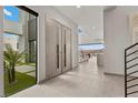 A modern home's foyer features tile floors, double doors, high ceilings, and a view to the backyard with mountains beyond at 21 Canyon Bay Dr, Henderson, NV 89011