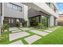 A meticulously landscaped front yard showcases modern design elements, including a stone pathway and verdant greenery at 21 Canyon Bay Dr, Henderson, NV 89011