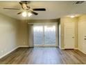 Bright living room featuring vinyl plank flooring, ceiling fan, and sliding glass door to backyard at 2420 Sweetgum St, Las Vegas, NV 89108