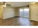 Open living room features vinyl plank flooring, ceiling fan, and door leading to outdoor space at 2420 Sweetgum St, Las Vegas, NV 89108