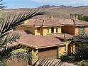 Desert home with a tile roof and attached two car garage, with mountain views in the background at 25 Via Mantova # 2, Henderson, NV 89011