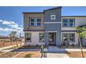 Contemporary two-story townhome boasts a gray and tan facade, landscaping, and a welcoming entrance at 4949 Apple Mesa Ave # 213, Las Vegas, NV 89139