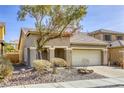 Tan one-story house with a two-car garage and mature tree at 6232 Novak St, Las Vegas, NV 89115