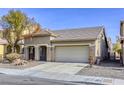 Tan two-story house with a two-car garage and landscaped yard at 6232 Novak St, Las Vegas, NV 89115