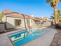 Backyard view of pool and patio with privacy fence and desert landscaping at 8474 Orange Cliff Ct, Las Vegas, NV 89123