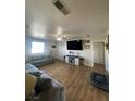 Comfortable living room featuring wood floors, a large TV, and a gray sofa at 1737 W Nelson Ave, North Las Vegas, NV 89032