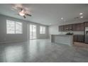 Open living room and kitchen with gray tile floors and modern lighting fixtures at 2240 Sky Island Dr, Henderson, NV 89002