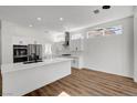 Modern kitchen with white cabinets, island, and breakfast nook at 3021 Isaac River Dr, Las Vegas, NV 89134