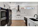 Modern kitchen with white cabinets, black appliances, and quartz countertops at 3021 Isaac River Dr, Las Vegas, NV 89134