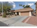 Tan house with a two-car garage and mature trees in front at 3126 Cabachon Ave, Las Vegas, NV 89121