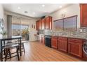 Kitchen features wood cabinets, tile backsplash, and breakfast nook at 3952 Moon Tango St, Las Vegas, NV 89129