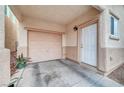 Attached garage with white door and light beige garage door at 4064 Emerald Wood St, Las Vegas, NV 89115