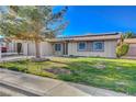 Cozy home with a well-kept lawn, mature landscaping, and a grey two-car garage at 4512 Mark Ave, Las Vegas, NV 89108