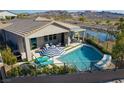 Private backyard oasis featuring a refreshing pool, patio area, and serene water views at 5625 W Agate Ave, Las Vegas, NV 89139