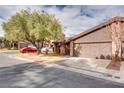 Brick house with a two-car garage and mature landscaping at 6520 Brushwood Ln, Las Vegas, NV 89107