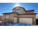 Tan two-story house with a two-car garage and nicely landscaped yard at 7511 Shadow Estates Way, Las Vegas, NV 89113