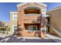 Two-story building with tan and orange exterior, balconies, and stairs at 8101 W Flamingo Rd # 1157, Las Vegas, NV 89147