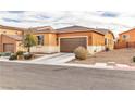 Tan house with brown garage door and desert landscaping at 825 Great Sky Ct, North Las Vegas, NV 89084