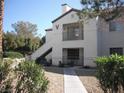 Charming condo featuring a stucco exterior with a balcony and stairs leading to the upper level at 9070 Spring Mountain Rd # 113, Las Vegas, NV 89117